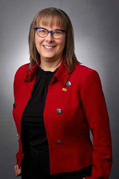 Image of Rachel Miller FCPA FCA, CEO of CPA Alberta. Rachel is facing the camera and smiling. She is wearing glasses and a black top with a red blazer. 