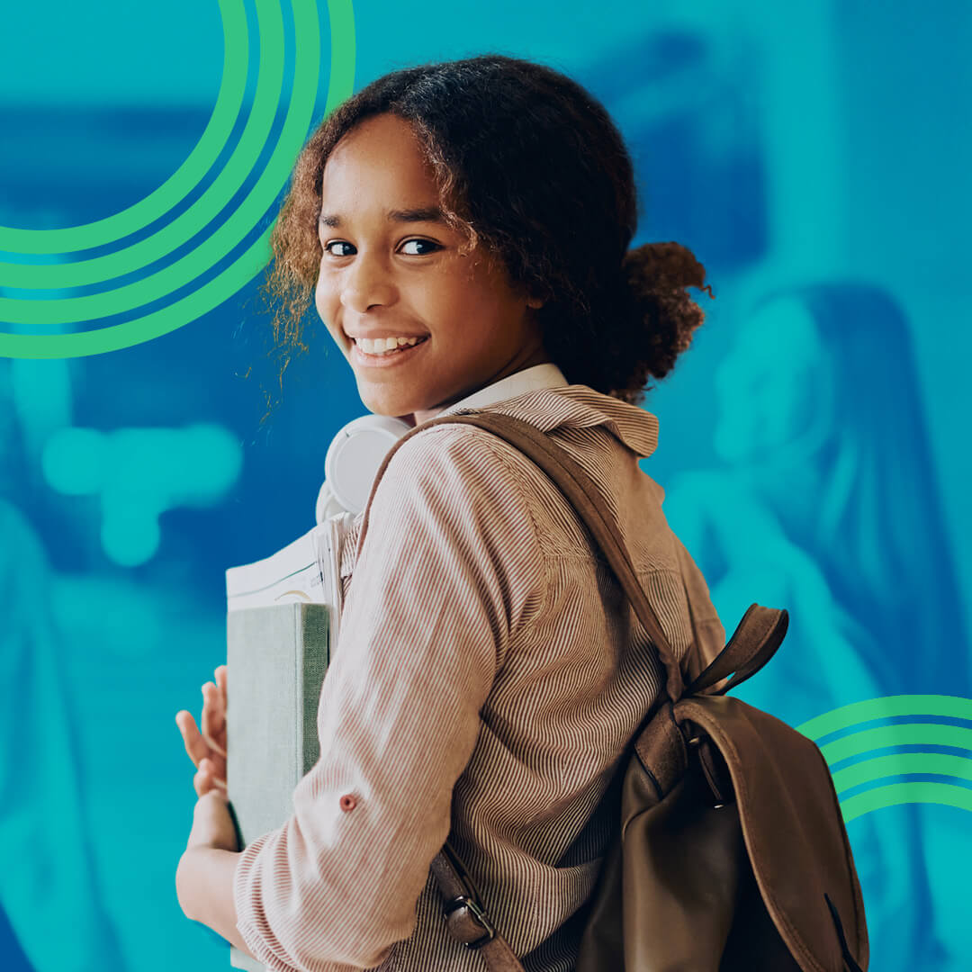 Image of a student wearing a backpack and smiling at the camera