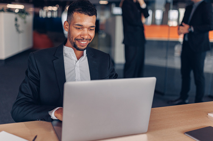 Image of a student wearing a backpack and smiling at the camera
