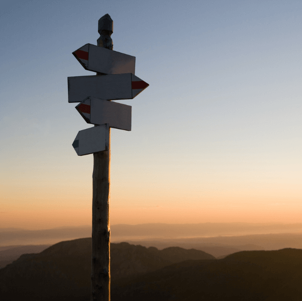 Directional signage with sunset background