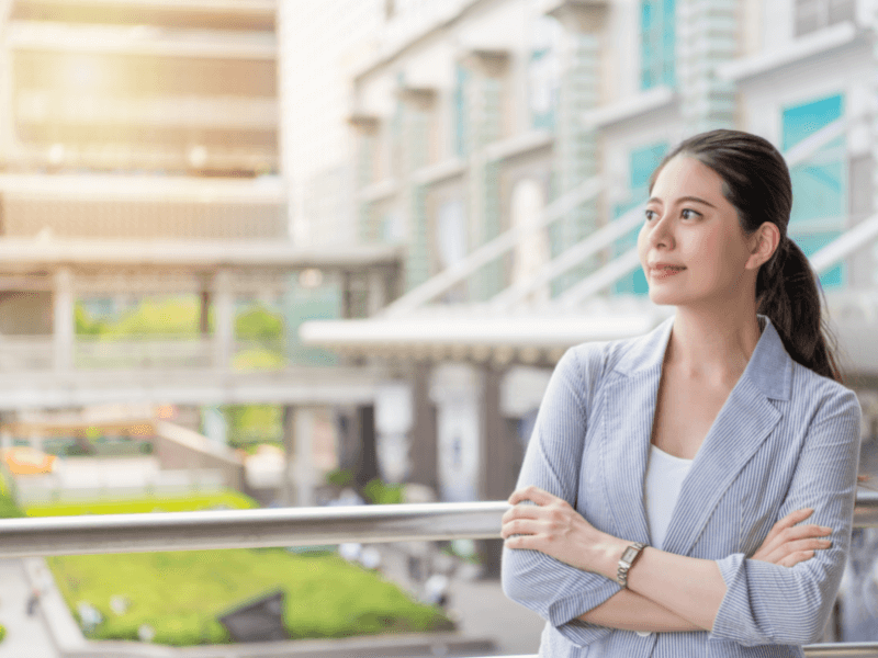 Woman looking out window confidently